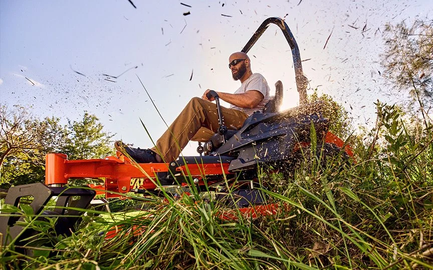 Professional landscaper operating a Kawasaki-powered commercial zero-turn mower