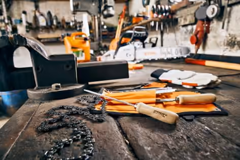 Saw chain and maintenance accessories on a workshop bench