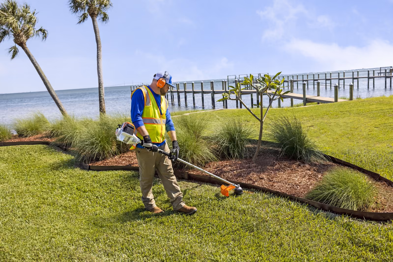 Landscaper trimming grass with a STIHL trimmer