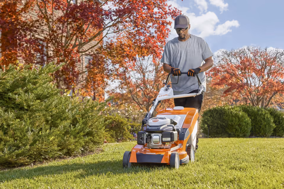 Operator mowing a lawn with a STIHL walk-behind mower